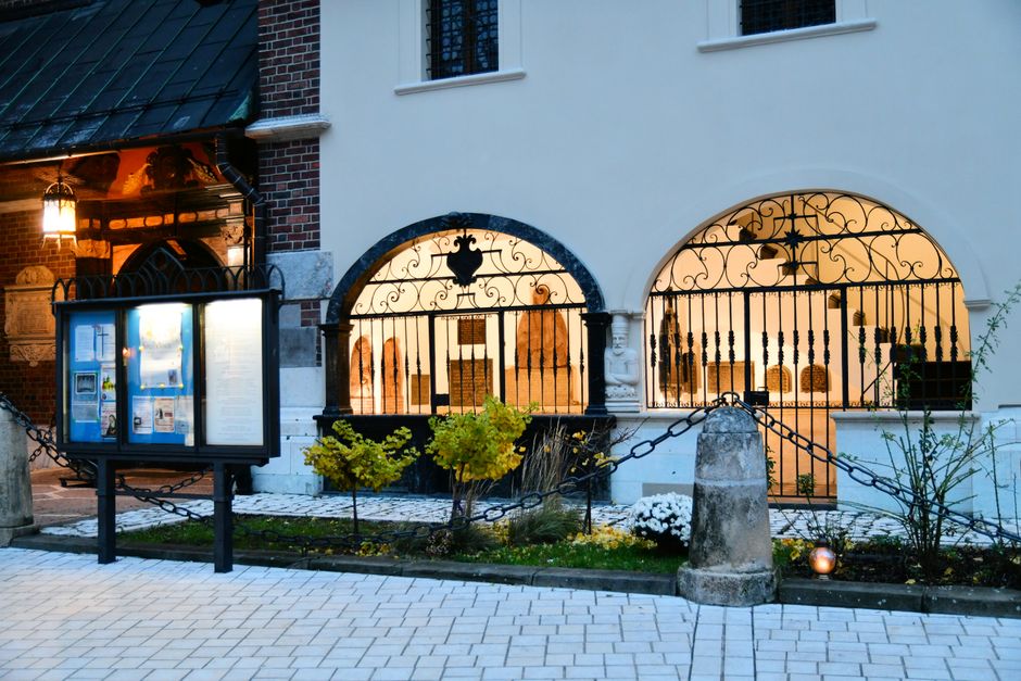 A beautifully lit urban building with ornate ironwork and glowing lamps, captured at twilight.
